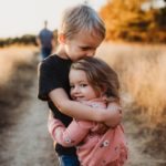 boy in black t-shirt hugging girl in red and white polka dot dress